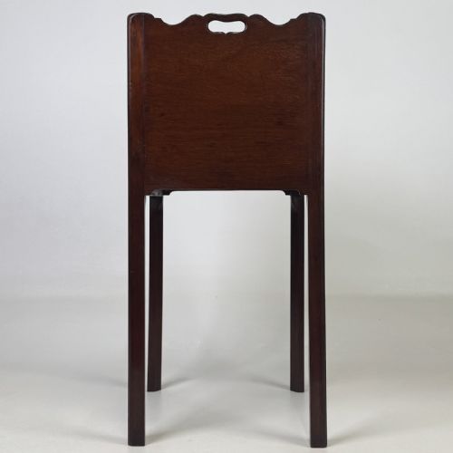 fig 2. A tall dark mahogany bedside cabinet featuring a gallery tray top, single cupboard door, and square legs.