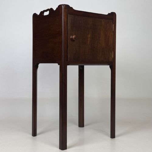 fig 7. A tall dark mahogany bedside cabinet featuring a gallery tray top, single cupboard door, and square legs.
