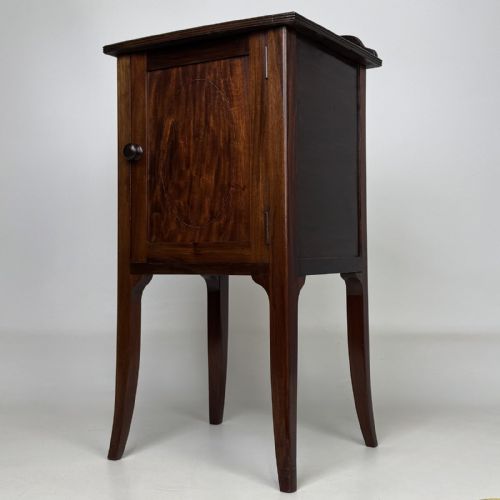fig 2. An Edwardian mahogany bedside cabinet with an inlaid oval door panel and slim square tapered legs.