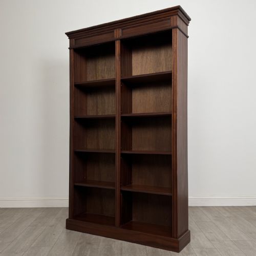 fig 1. A tall, dark mahogany double-bay open bookcase featuring multiple shelves, a moulded cornice top, and a solid plinth base.