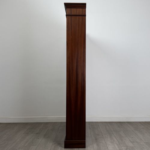 fig 2. A tall, dark mahogany double-bay open bookcase featuring multiple shelves, a moulded cornice top, and a solid plinth base.