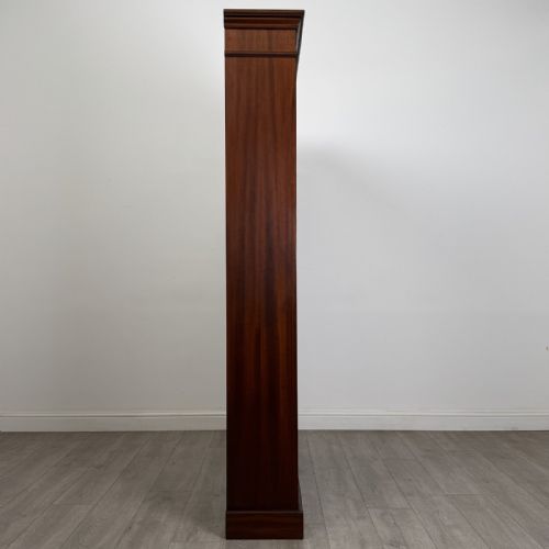 fig 6. A tall, dark mahogany double-bay open bookcase featuring multiple shelves, a moulded cornice top, and a solid plinth base.