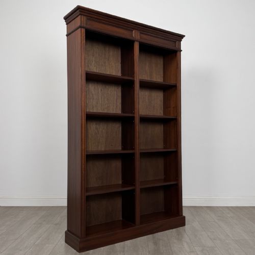 fig 7. A tall, dark mahogany double-bay open bookcase featuring multiple shelves, a moulded cornice top, and a solid plinth base.