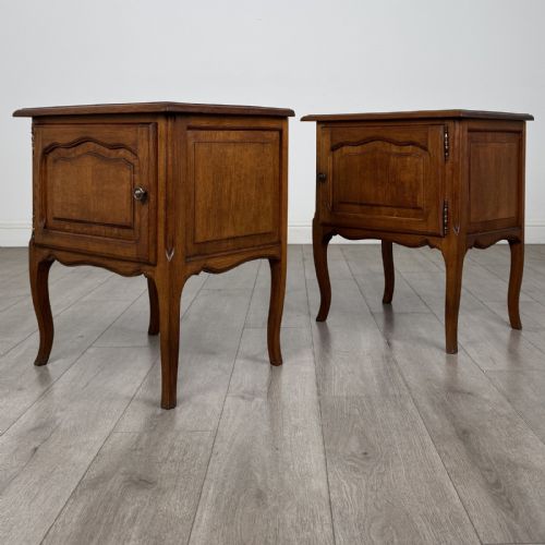 fig 2. A matching pair of vintage warm oak French style bedside cabinets featuring cabriole legs, single panelled doors, and metal knobs.