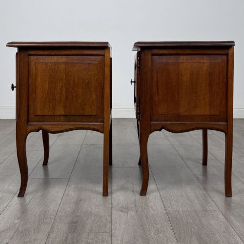 fig 3. A matching pair of vintage warm oak French style bedside cabinets featuring cabriole legs, single panelled doors, and metal knobs.