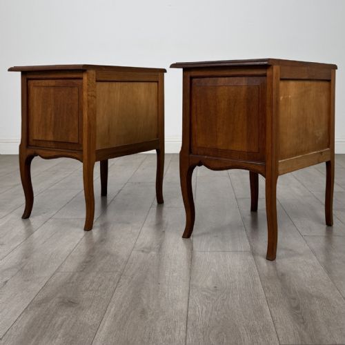 fig 4. A matching pair of vintage warm oak French style bedside cabinets featuring cabriole legs, single panelled doors, and metal knobs.