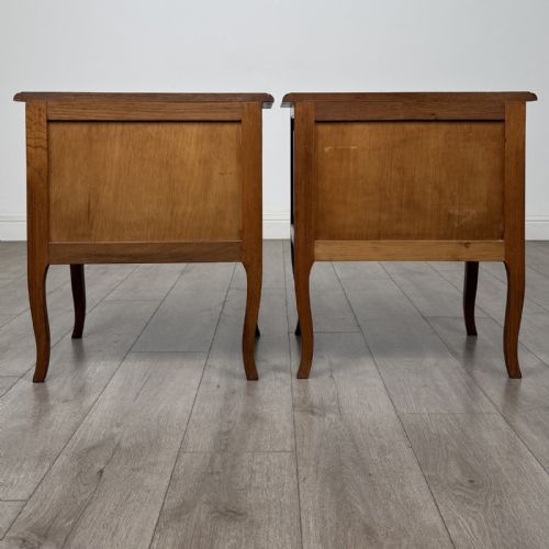 fig 5. A matching pair of vintage warm oak French style bedside cabinets featuring cabriole legs, single panelled doors, and metal knobs.