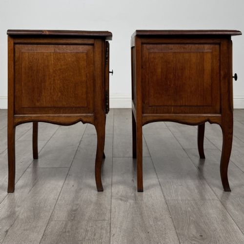 fig 7. A matching pair of vintage warm oak French style bedside cabinets featuring cabriole legs, single panelled doors, and metal knobs.