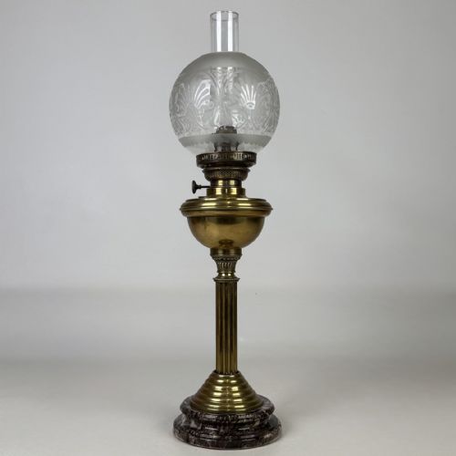 fig 1. An antique brass column oil lamp featuring an etched glass globe shade, clear chimney, brass reservoir, fluted stem, and dark veined marble base.