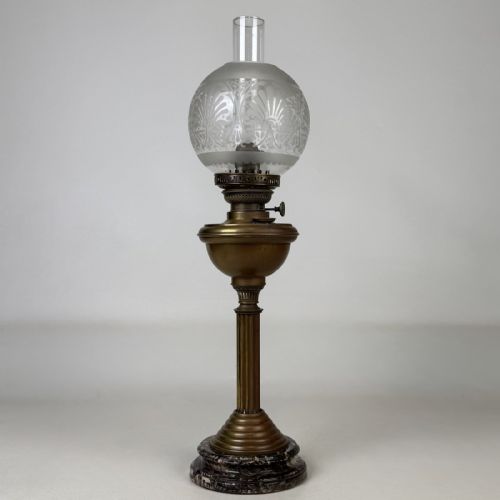 fig 2. An antique brass column oil lamp featuring an etched glass globe shade, clear chimney, brass reservoir, fluted stem, and dark veined marble base.