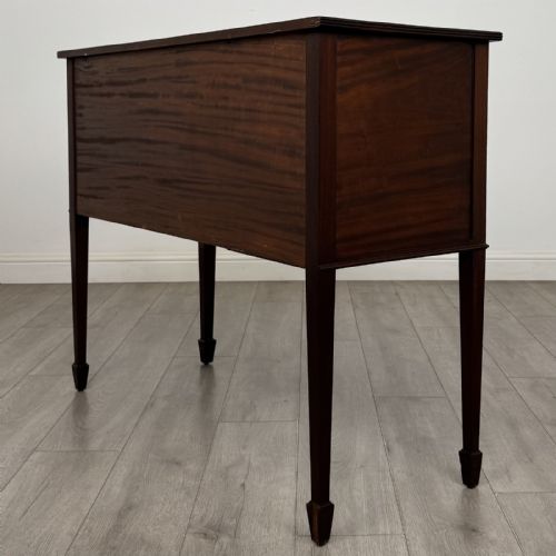 fig 5. A mahogany bowfront sideboard featuring two oval-inlaid cupboard doors flanking a central drawer, set upon four square tapered legs with spade feet.