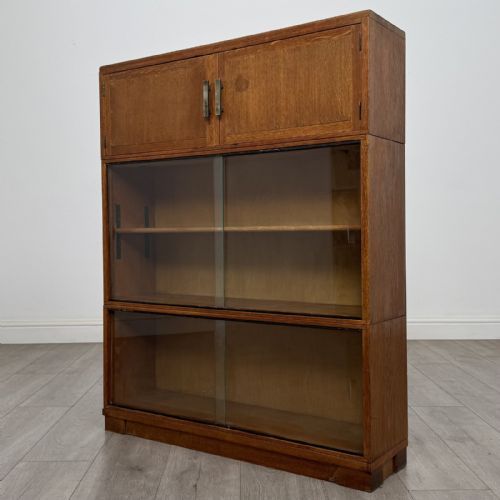 fig 2. A 20th-century oak stacking bookcase featuring a double-door wooden top cabinet above two tiered sliding glass door compartments.