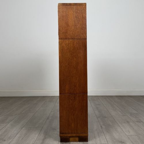 fig 3. A 20th-century oak stacking bookcase featuring a double-door wooden top cabinet above two tiered sliding glass door compartments.
