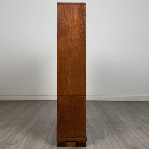 fig 7. A 20th-century oak stacking bookcase featuring a double-door wooden top cabinet above two tiered sliding glass door compartments.
