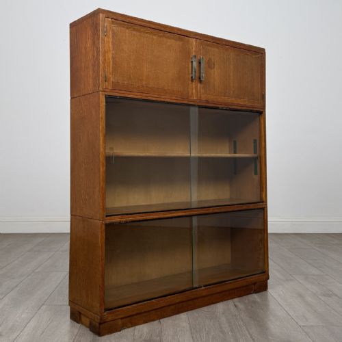 fig 8. A 20th-century oak stacking bookcase featuring a double-door wooden top cabinet above two tiered sliding glass door compartments.