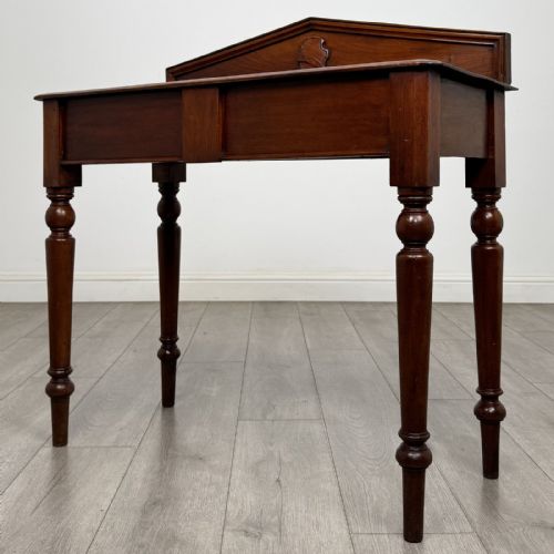 fig 1. A dark mahogany Victorian side table with turned legs and a low pediment gallery back.