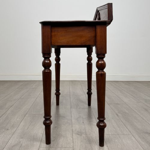 fig 2. A dark mahogany Victorian side table with turned legs and a low pediment gallery back.