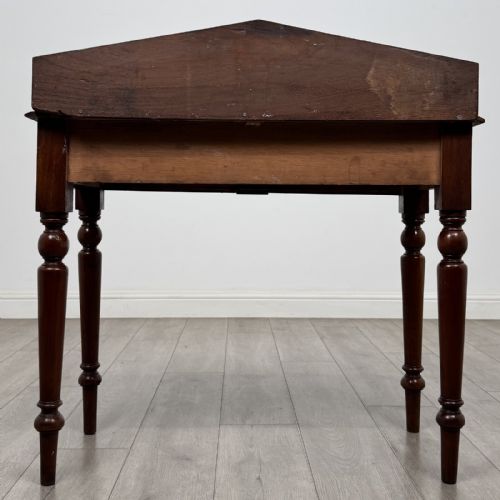fig 4. A dark mahogany Victorian side table with turned legs and a low pediment gallery back.