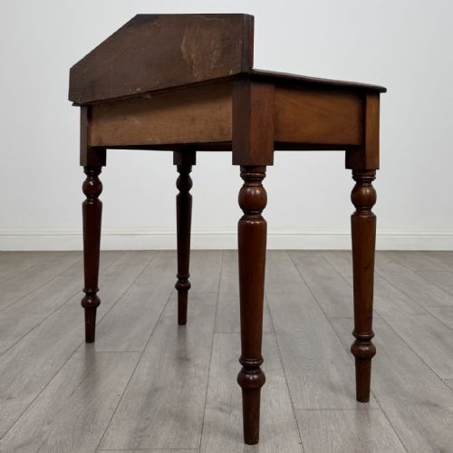 fig 5. A dark mahogany Victorian side table with turned legs and a low pediment gallery back.