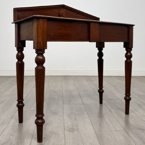fig 7. A dark mahogany Victorian side table with turned legs and a low pediment gallery back.
