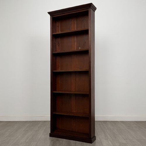 fig 2. A tall, narrow mahogany open bookcase featuring six shelving compartments, a moulded top cornice, and a solid plinth base.