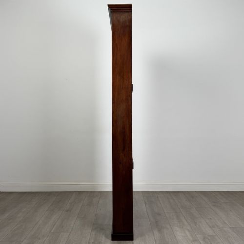 fig 3. A tall, narrow mahogany open bookcase featuring six shelving compartments, a moulded top cornice, and a solid plinth base.