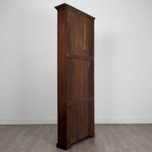 fig 4. A tall, narrow mahogany open bookcase featuring six shelving compartments, a moulded top cornice, and a solid plinth base.