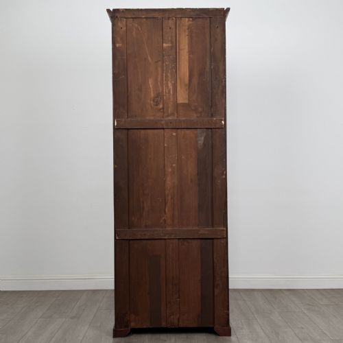 fig 5. A tall, narrow mahogany open bookcase featuring six shelving compartments, a moulded top cornice, and a solid plinth base.