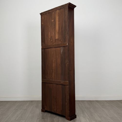 fig 6. A tall, narrow mahogany open bookcase featuring six shelving compartments, a moulded top cornice, and a solid plinth base.