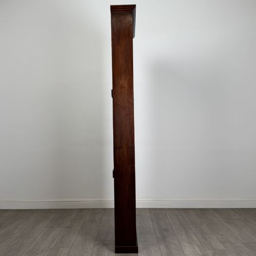 fig 7. A tall, narrow mahogany open bookcase featuring six shelving compartments, a moulded top cornice, and a solid plinth base.