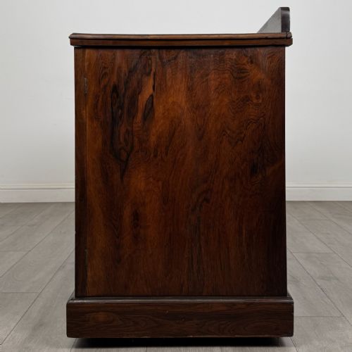 fig 2. A dark rosewood Victorian breakfront sideboard with three cupboard doors featuring intricate satinwood urn and scroll marquetry inlays.