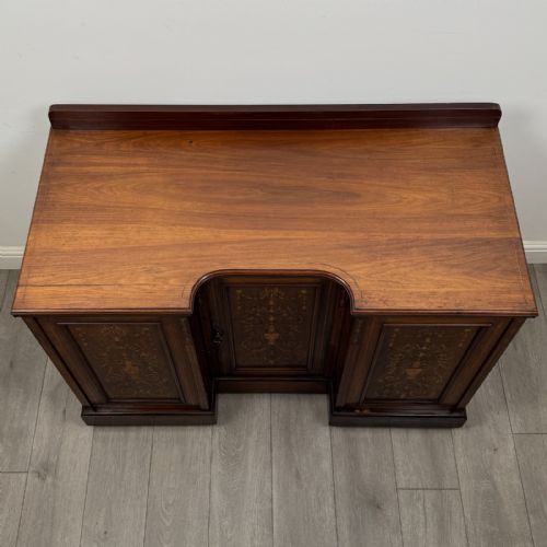 fig 8. A dark rosewood Victorian breakfront sideboard with three cupboard doors featuring intricate satinwood urn and scroll marquetry inlays.