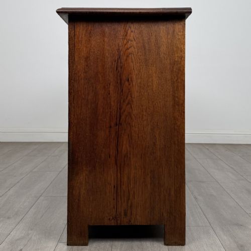 fig 2. A dark oak early 20th-century sideboard featuring two top drawers with circular brass ring pulls over two panelled cupboard doors.