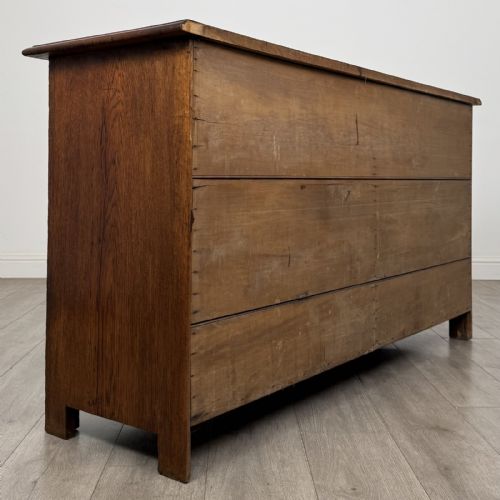 fig 3. A dark oak early 20th-century sideboard featuring two top drawers with circular brass ring pulls over two panelled cupboard doors.