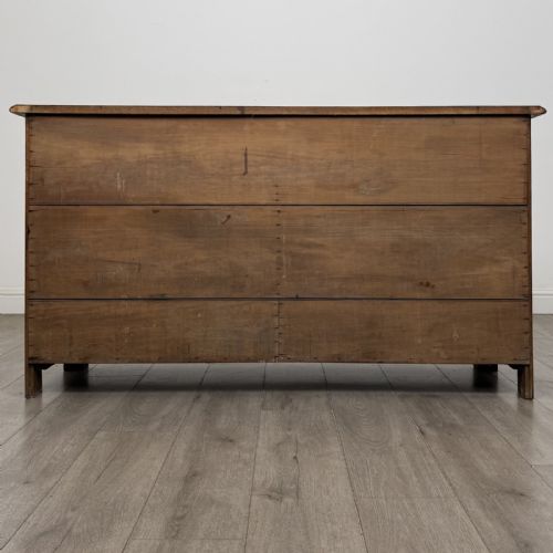 fig 4. A dark oak early 20th-century sideboard featuring two top drawers with circular brass ring pulls over two panelled cupboard doors.