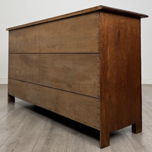 fig 5. A dark oak early 20th-century sideboard featuring two top drawers with circular brass ring pulls over two panelled cupboard doors.