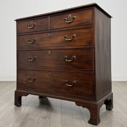 fig 1. An 18th-century Georgian mahogany chest of drawers featuring a two-over-three drawer configuration with brass swan-neck handles and bracket feet.