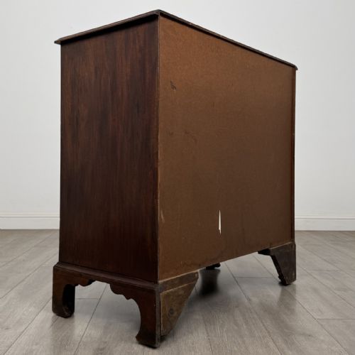 fig 3. An 18th-century Georgian mahogany chest of drawers featuring a two-over-three drawer configuration with brass swan-neck handles and bracket feet.