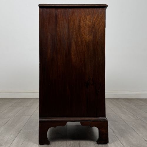 fig 6. An 18th-century Georgian mahogany chest of drawers featuring a two-over-three drawer configuration with brass swan-neck handles and bracket feet.