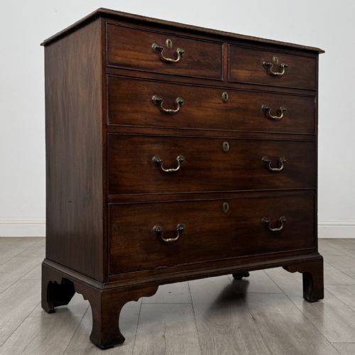 fig 7. An 18th-century Georgian mahogany chest of drawers featuring a two-over-three drawer configuration with brass swan-neck handles and bracket feet.