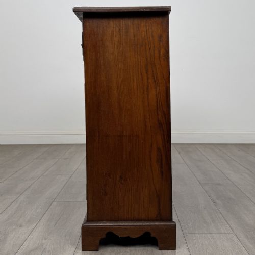 fig 2. A Georgian style warm brown oak dresser base featuring two drawers with brass drop handles above two panelled cupboard doors, raised on bracket feet.
