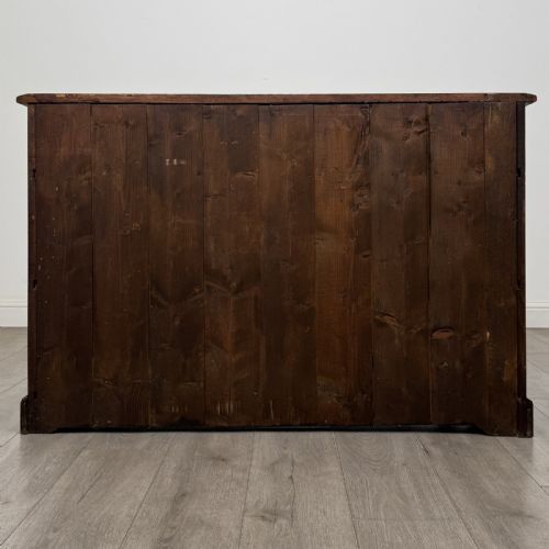 fig 4. A Georgian style warm brown oak dresser base featuring two drawers with brass drop handles above two panelled cupboard doors, raised on bracket feet.
