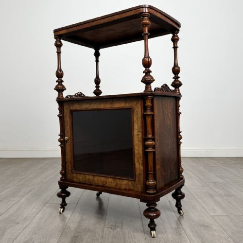 fig 1. A Victorian burr walnut cabinet featuring an upper tier with turned columns above a single glazed cupboard door with marquetry inlay.