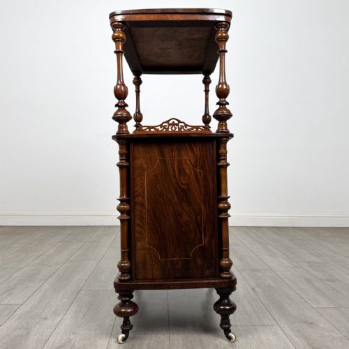 fig 2. A Victorian burr walnut cabinet featuring an upper tier with turned columns above a single glazed cupboard door with marquetry inlay.