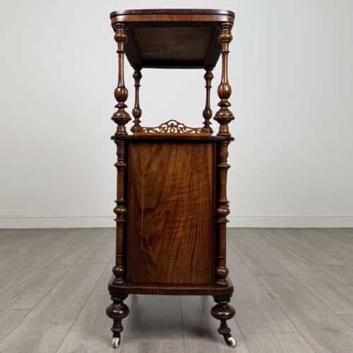 fig 6. A Victorian burr walnut cabinet featuring an upper tier with turned columns above a single glazed cupboard door with marquetry inlay.