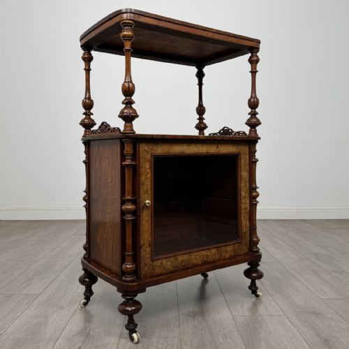 fig 7. A Victorian burr walnut cabinet featuring an upper tier with turned columns above a single glazed cupboard door with marquetry inlay.