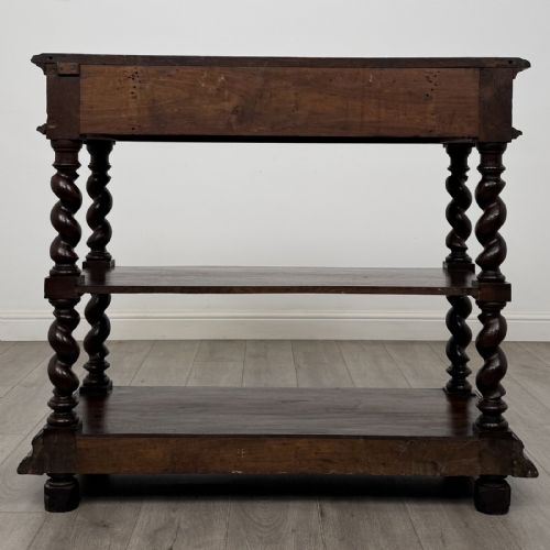 fig 4. A dark oak three-tier buffet featuring relief foliage carving across the top drawer frieze and four barley twist corner support legs.