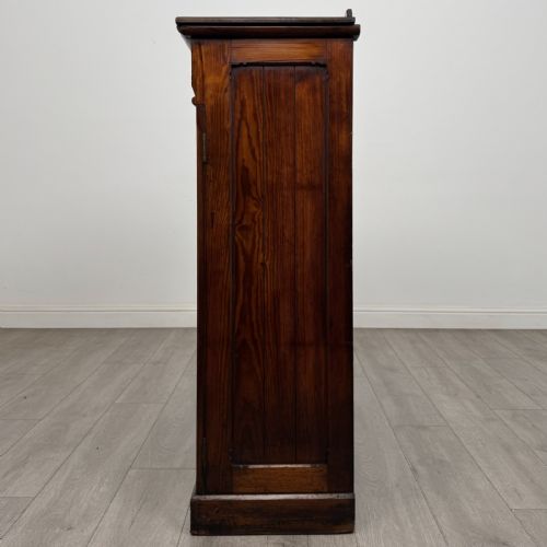fig 2. A Victorian pitch pine cupboard featuring a single top drawer with brass drop ring handles above a two-door cabinet with vertical panelled detailing.