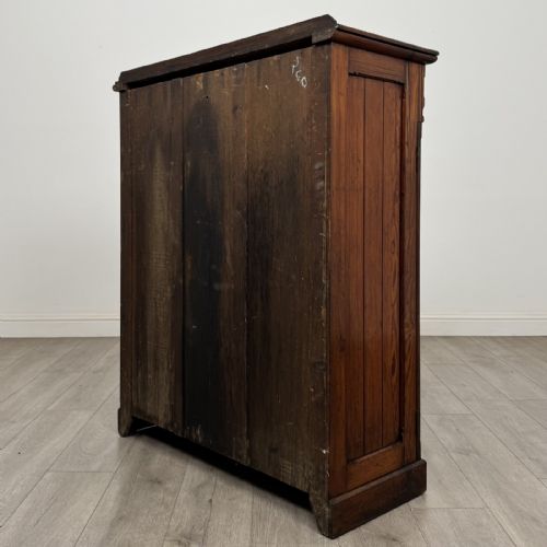 fig 5. A Victorian pitch pine cupboard featuring a single top drawer with brass drop ring handles above a two-door cabinet with vertical panelled detailing.