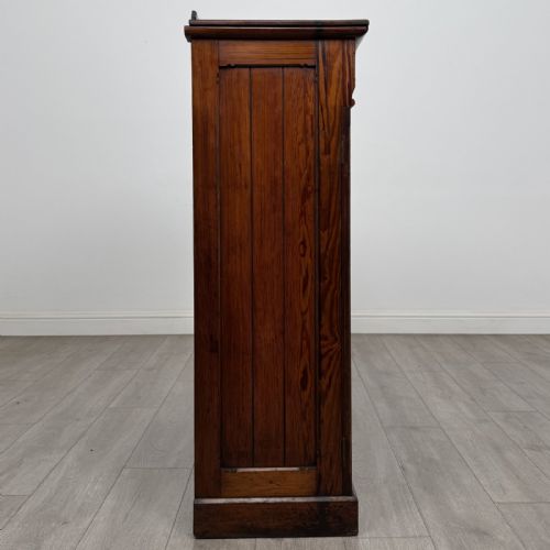 fig 6. A Victorian pitch pine cupboard featuring a single top drawer with brass drop ring handles above a two-door cabinet with vertical panelled detailing.